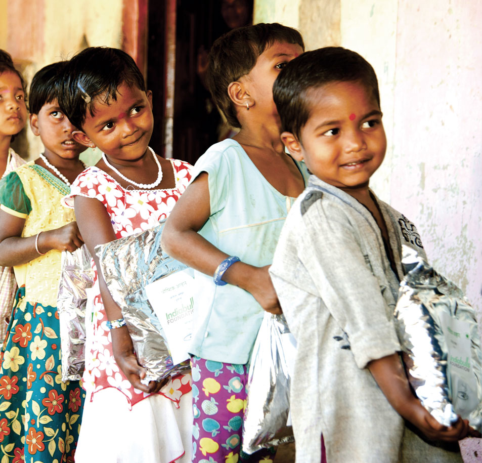 Child holding packet of Paushtik Aahar - Nutrition Supplement distributed by Indiabulls Foundation